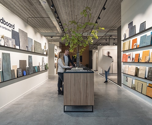 Lange wand met kleurrijke tegel moodboards in de showroom van TÉGL