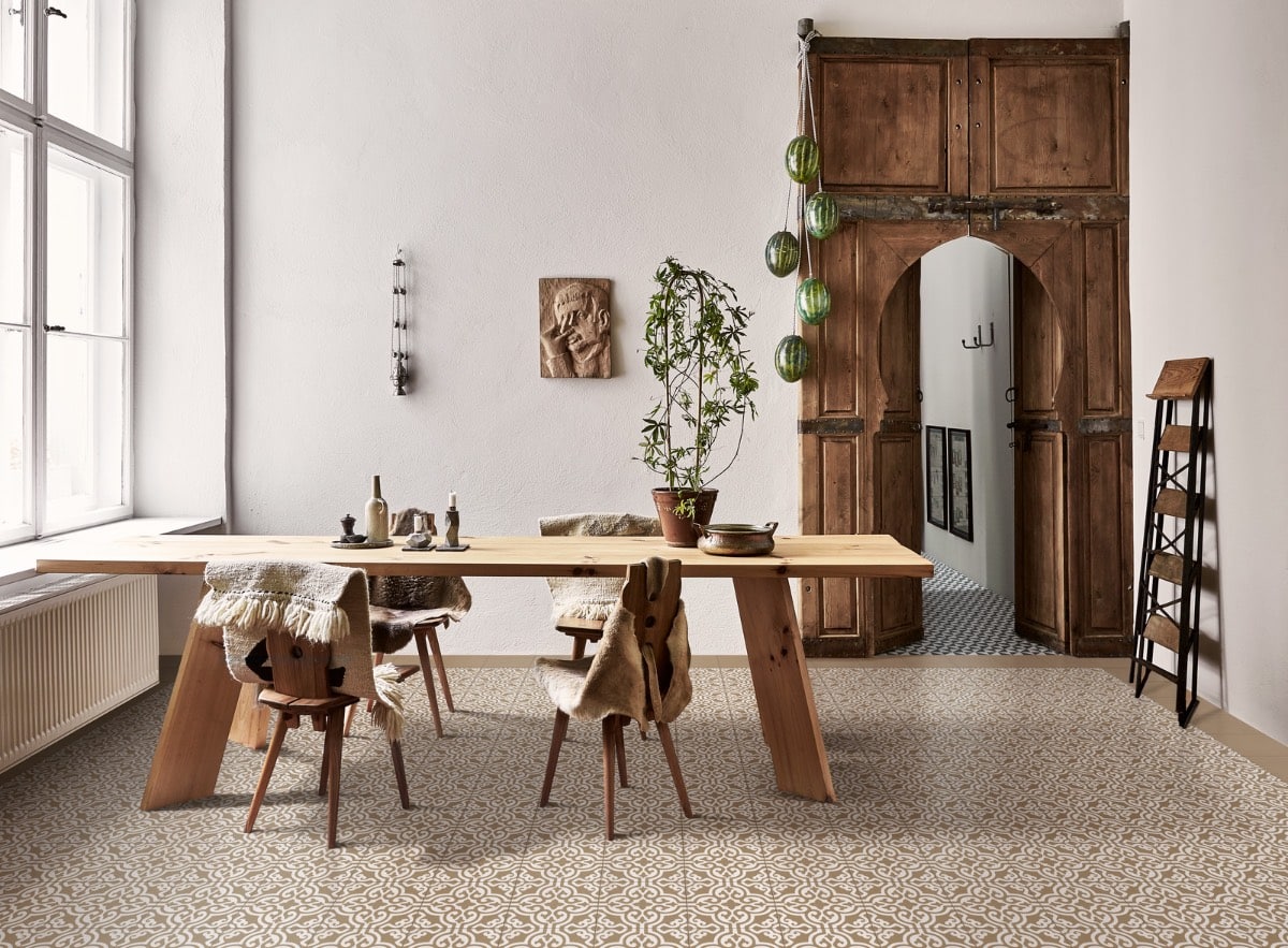 Eetkamer ingericht met houten meubels, een lange eettafel en stoelen, en een vloer bedekt met sierlijke Portugese tegels in een beige patroon, die een warme en uitnodigende sfeer creëren.